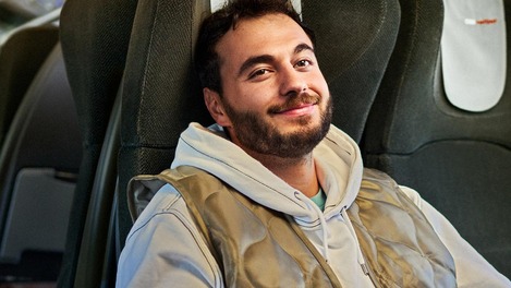 Sujet "Vorteil auch fürs Hinterteil", Fahrgast sitzt zufrieden auf seinem reservierten Sitzplatz