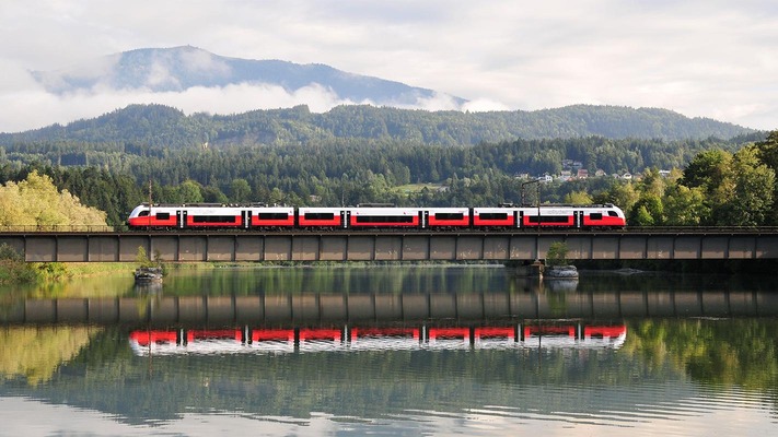Cityjet fährt über Brücke im Sommer