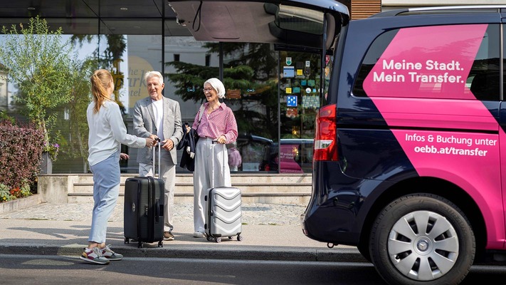 Menschen mit Reisekoffer stehen neben ÖBB Transfer Shuttle