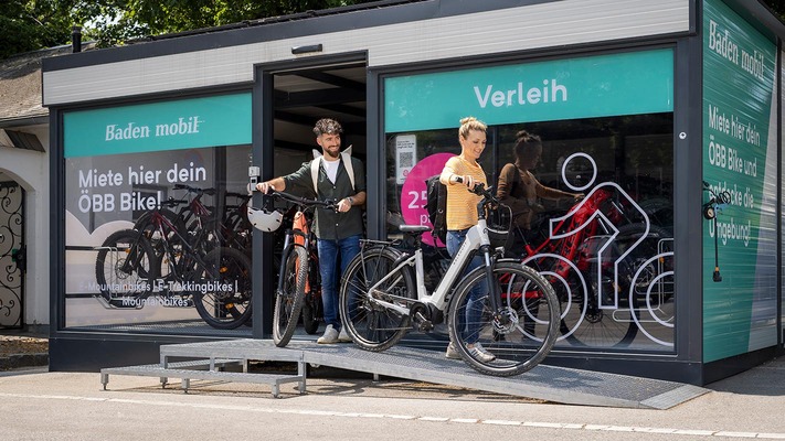 Zwei Personen schieben E-Bikes neben sich her