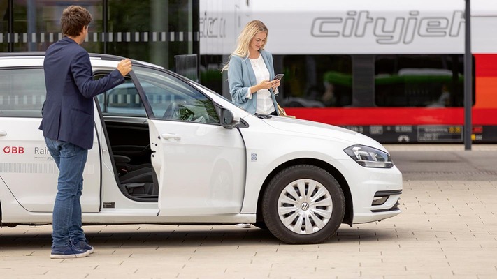 Personen stehen vor Rail&Drive Auto