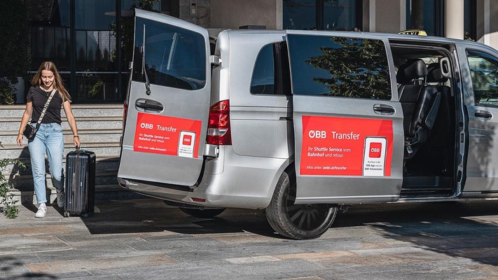 Frau steigt mit Koffer in Shuttle-Transfer