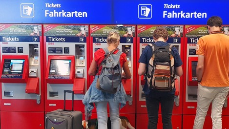 People stand in front of ticket machines