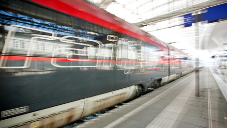 Railjet fährt durch Bahnhof