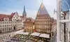 Historischer Marktplatz in Hildesheim mit prächtigen Fachwerkhäusern, Außengastronomie und Blick auf die St.-Andreas-Kirche bei sonnigem Wetter.
