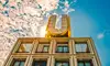 Das in Dortmund aufgenommene Foto zeigt das Gebäude "Dortmunder U". Auf dem Gebäude befindet sich ein großer Buchstabe "U", durch den die Sonne scheint. Der Himmel ist blau mit vereinzelten Wolken. <br/>
