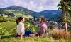 Ein Paar sitzt inmitten der Weinberge von Sasbachwalden und genießt ein Glas Wein mit Blick auf das malerische Dorf und die umliegenden Hügel
