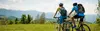 Young couple with bicycles in front of a beautiful mountain landscape