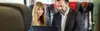 Mann und Frau in Business-Abteil schauen auf Laptop