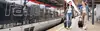 Reisende mit Gepäck am Bahnsteig