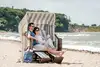 Paar entspannt im Strandkorb auf dem Ostseestrand
