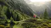Wanderer in den Bergen vor blühenden Wiesen