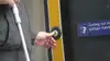 Fahrgast drückt Knopf bei barrierefreiem Einstieg