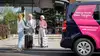 Menschen mit Reisekoffer stehen neben ÖBB Transfer Shuttle