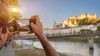 Person fotographiert Salzburg Stadt mit Smartphone