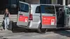 Frau steigt mit Koffer in Shuttle-Transfer