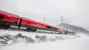 Railjet fährt durch schneebedeckte Landschaft