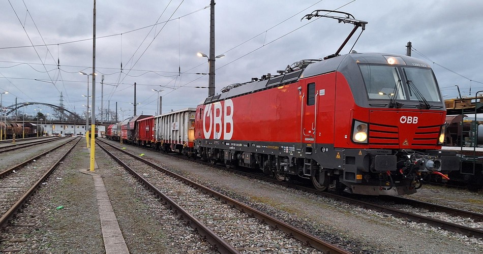 DAC demonstration freight train standing on railway tracks in a rail yard.