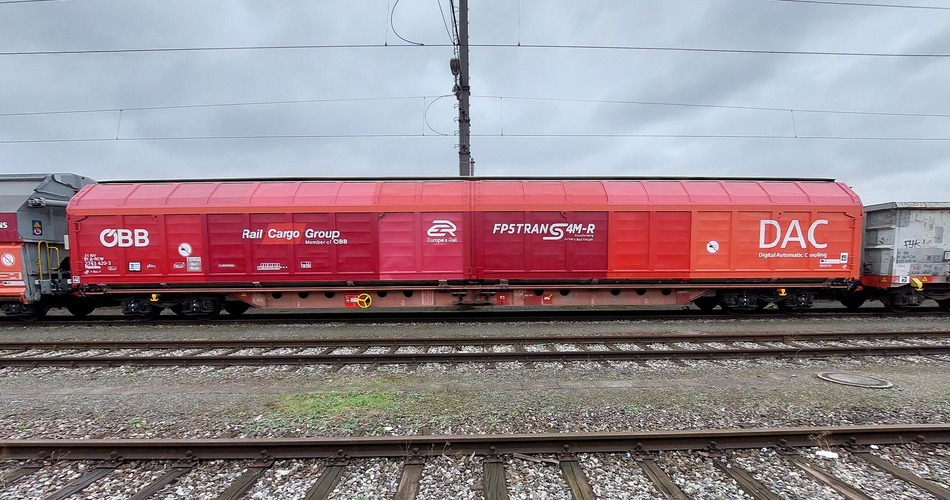 Habbiins freight wagon marked for DAC testing standing on railway tracks.