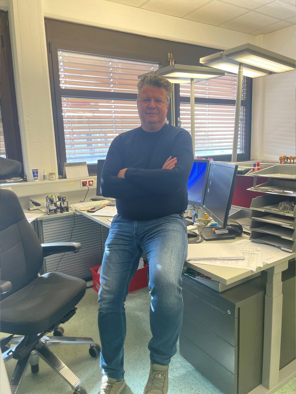 Member of the Rail Cargo Group (RCG) customs team in Wolfurt, sitting on a desk in an office.