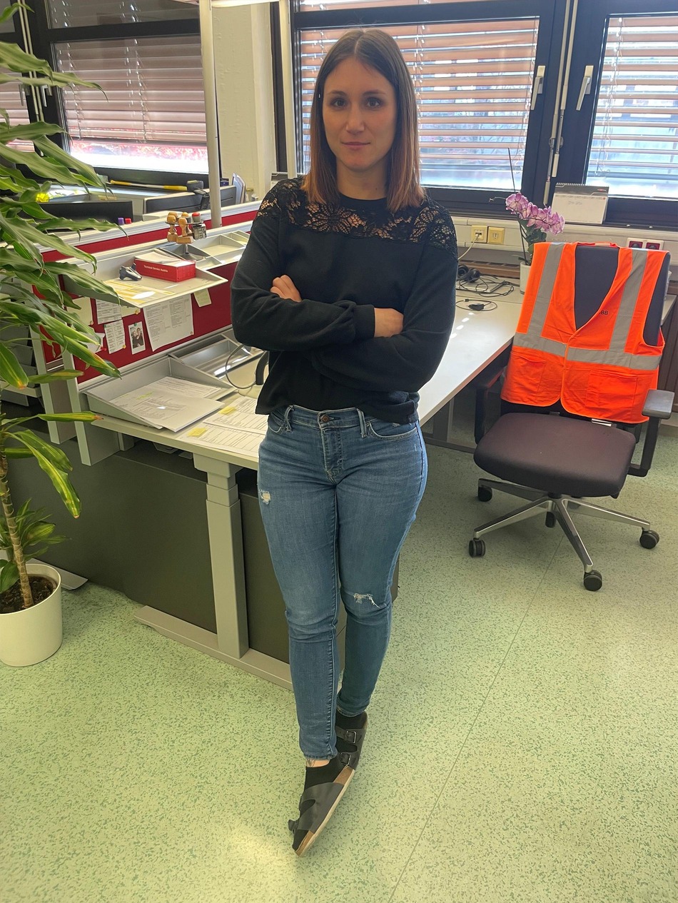 Member of the Rail Cargo Group (RCG) customs team in Wolfurt, standing in an office with arms crossed.