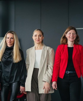 Three Rail Cargo Group colleagues standing together indoors in business attire
