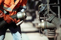 Arbeiter beim Anschließen eines Schlauchs im Bereich Mineralöl.