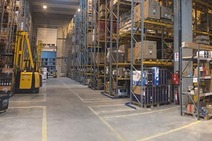 Lagerhalle in Bosnien und Herzegowina mit hohen Regalen voller Kartons und Paletten