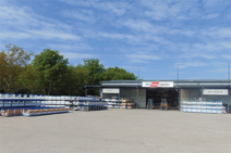 Warehouse Novi Zagreb with exterior view, stacked metal racks, and forklifts in front of the building