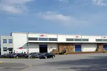 Warehouse Zagreb with exterior view of the building, parked cars, and forklift at the loading area