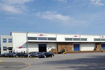 Warehouse Zagreb with exterior view of the building, parked cars, and forklift at the loading area