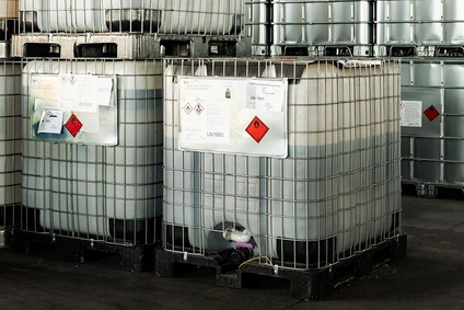 IBC containers with hazardous liquid chemicals stored on pallets in a warehouse