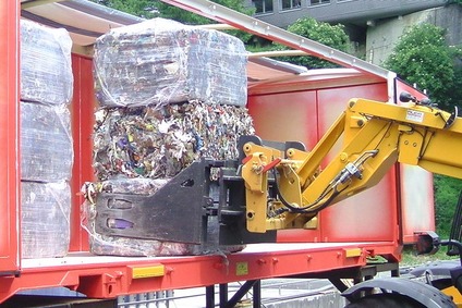 Loading compressed waste for disposal logistics.
