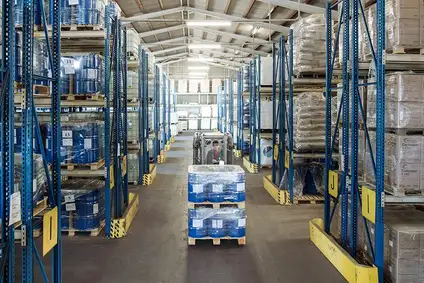 Warehouse in Austria with shelves, pallets and a forklift in operation.