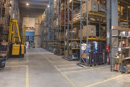 Warehouse in Bosnia with pallets, boxes and yellow forklifts.