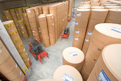 Gabelstapler bewegen große Papierrollen im Lager Wien Freudenau.