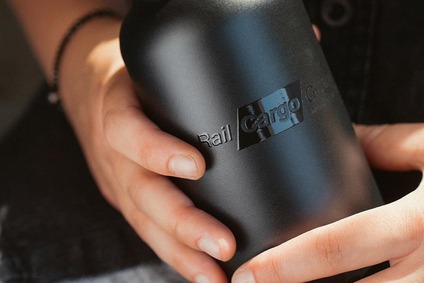 Hands holding a black water bottle with Rail Cargo logo