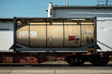 Tank container mounted on a flat freight wagon