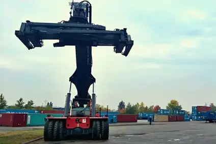 Container-Umschlagfahrzeug mit Hebevorrichtung auf einem Containerplatz.