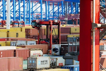Container terminal with colourful containers and cranes in operation.