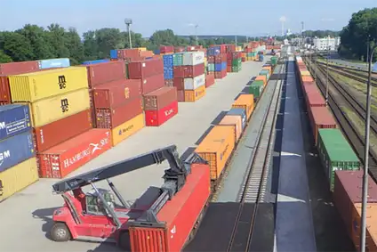 Gestapelte Container und ein Containerstapler in einem Terminal.