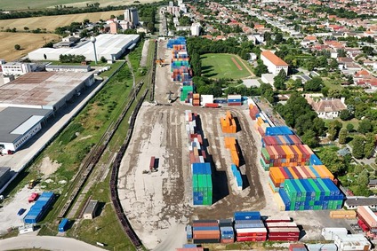 Luftaufnahme eines Containerterminals in Sládkovičovo mit gestapelten Containern, Gleisen und angrenzendem Stadtgebiet