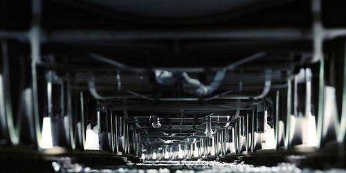 Blick unter einen Güterwagen auf Drehgestelle und Radsätze im Gleisbett