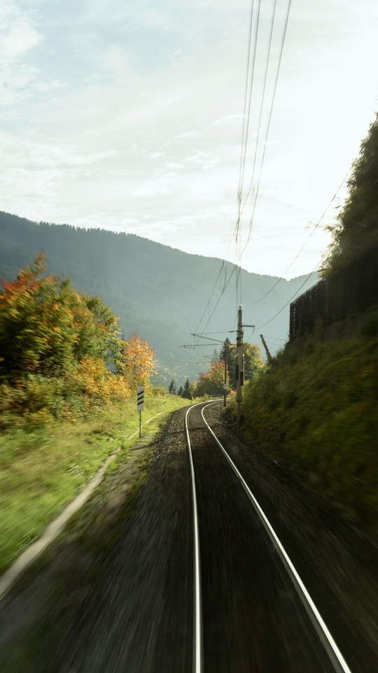 Railway track curving through a mountain landscape in autumn