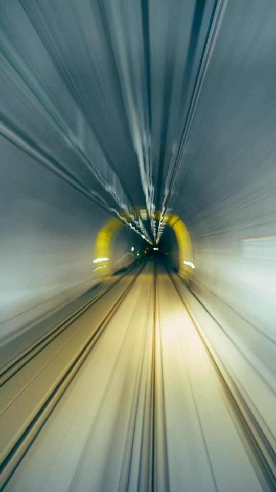 Motion-blurred view of railway tracks inside a tunnel
