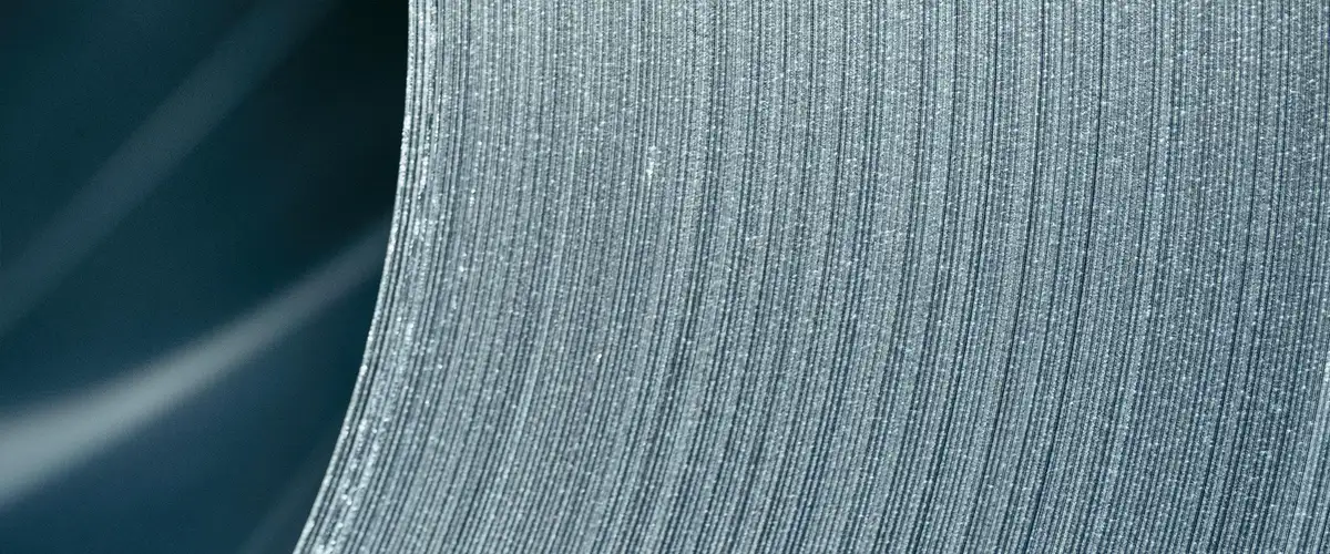 Detailaufnahme einer Stahloberfläche mit feinen parallelen Rillen