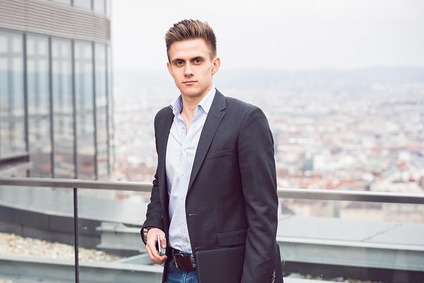 Sales employee standing on a rooftop terrace overlooking a city