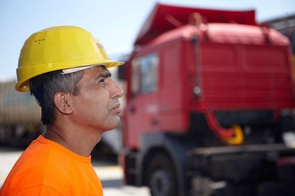 Terminal employee wearing a hard hat standing near rail equipment