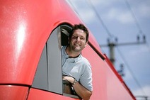 Triebfahrzeugführer lehnt aus dem Fenster eines Führerstands