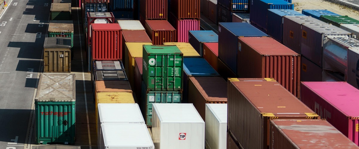 Bunte Frachtcontainer in Reihen gestapelt auf einem Containerterminal